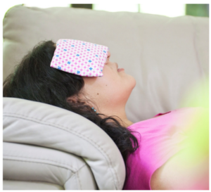 Mujer descansando con Eye Pillow o almohadita de ojos en un sofa